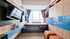 A modern room with a bed, a TV, and a window with curtains. - Cozy Studio With Murphy Bed At Collins Boulevard Apartment (Tangerang)