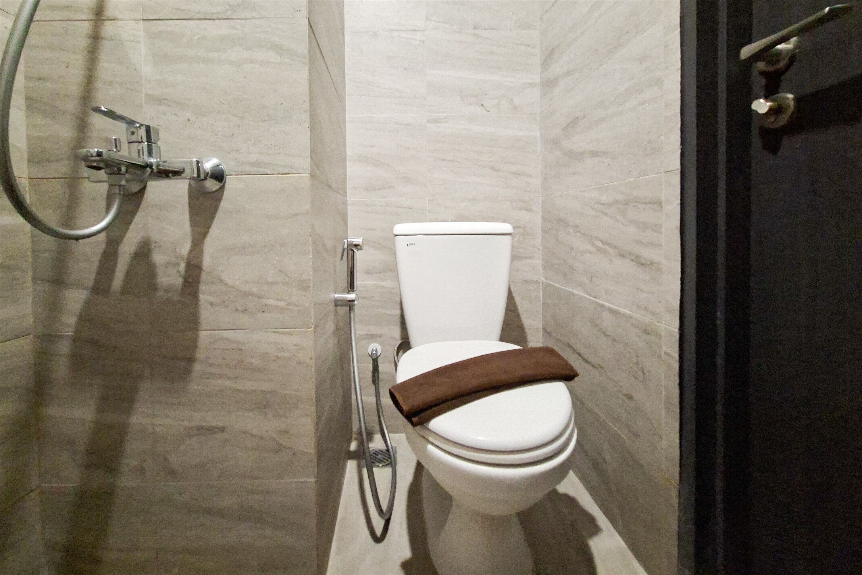 A bathroom with a toilet, a shower, and a door.
