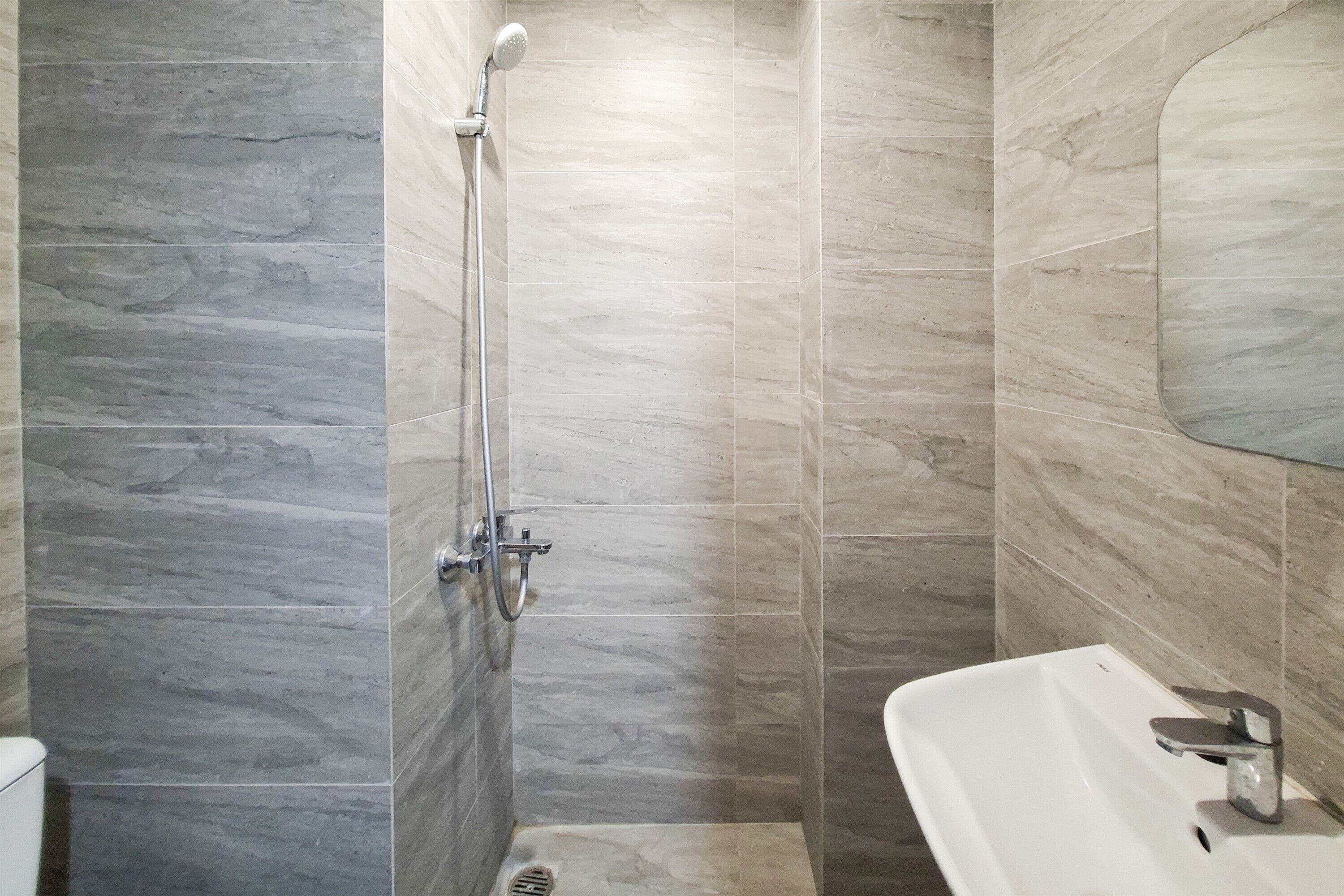 A bathroom with a shower, a sink, and a mirror.