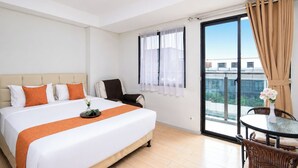 Een hotelkamer met een bed, een stoel, een tafel met een vaas en een balkon met gordijnen.