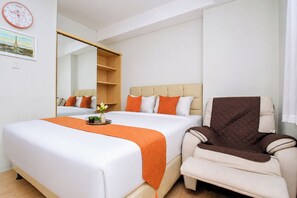 Ein Hotelzimmer mit zwei Betten, einem großen Spiegel, einem Sessel und einer Wanduhr.