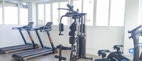A gym with treadmills, a weight machine, and a stationary bike.