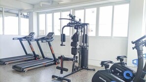 A gym with treadmills, a weight machine, and a stationary bike. - 2 Pax Neat Studio At De Prima Apartment (Medan)