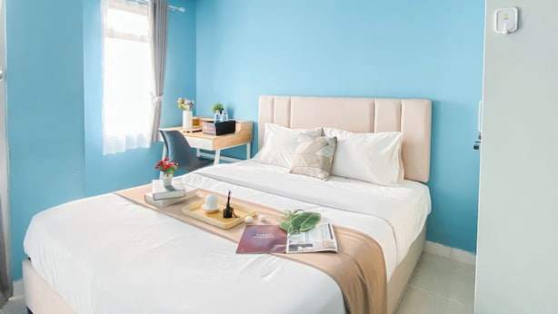 Ein Hotelzimmer mit Bett, Schreibtisch und Fenster.