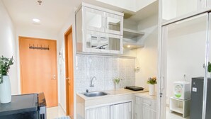 Une cuisine moderne avec des armoires blanches, un évier en acier inoxydable, un four à micro-ondes et un réfrigérateur.