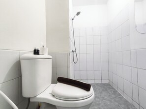 Ein kleines, modernes Badezimmer mit Toilette, Dusche und Handtuchhalter.