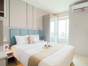Quarto de hotel moderno com uma cama grande, uma mesa de cabeceira, uma janela com vista para a cidade e um ar condicionado.