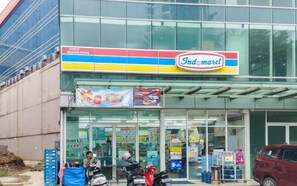 A storefront with a large glass entrance, a sign for Indomaret, and a display of products outside. - Restful 1Br With City View At Apartment Harco Mangga Besar (Jakarta)