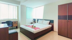Un dormitorio con cama, escritorio y armario.