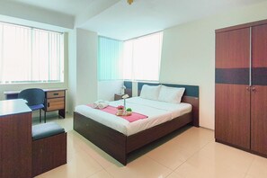 Ein Schlafzimmer mit Bett, Schreibtisch und Kleiderschrank.