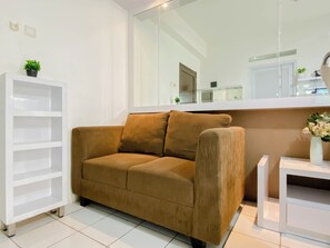 Una sala de estar moderna con un sofá marrón, una estantería blanca y una mesita con un florero.