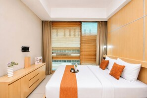 A modern hotel room with a large bed, wooden headboard, and a view through floor-to-ceiling windows. - Gorgeous And Cozy 2Br Apartment Kemang Village (Jakarta)
