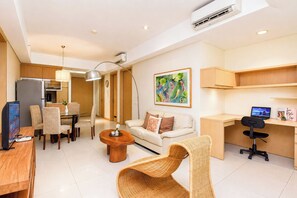 Uma sala de estar moderna com sofá, mesa de jantar, cadeiras, mesa de centro, escrivaninha e um laptop.