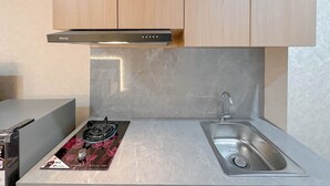 Una cocina con estufa a gas, un lavamanos y armarios de madera.