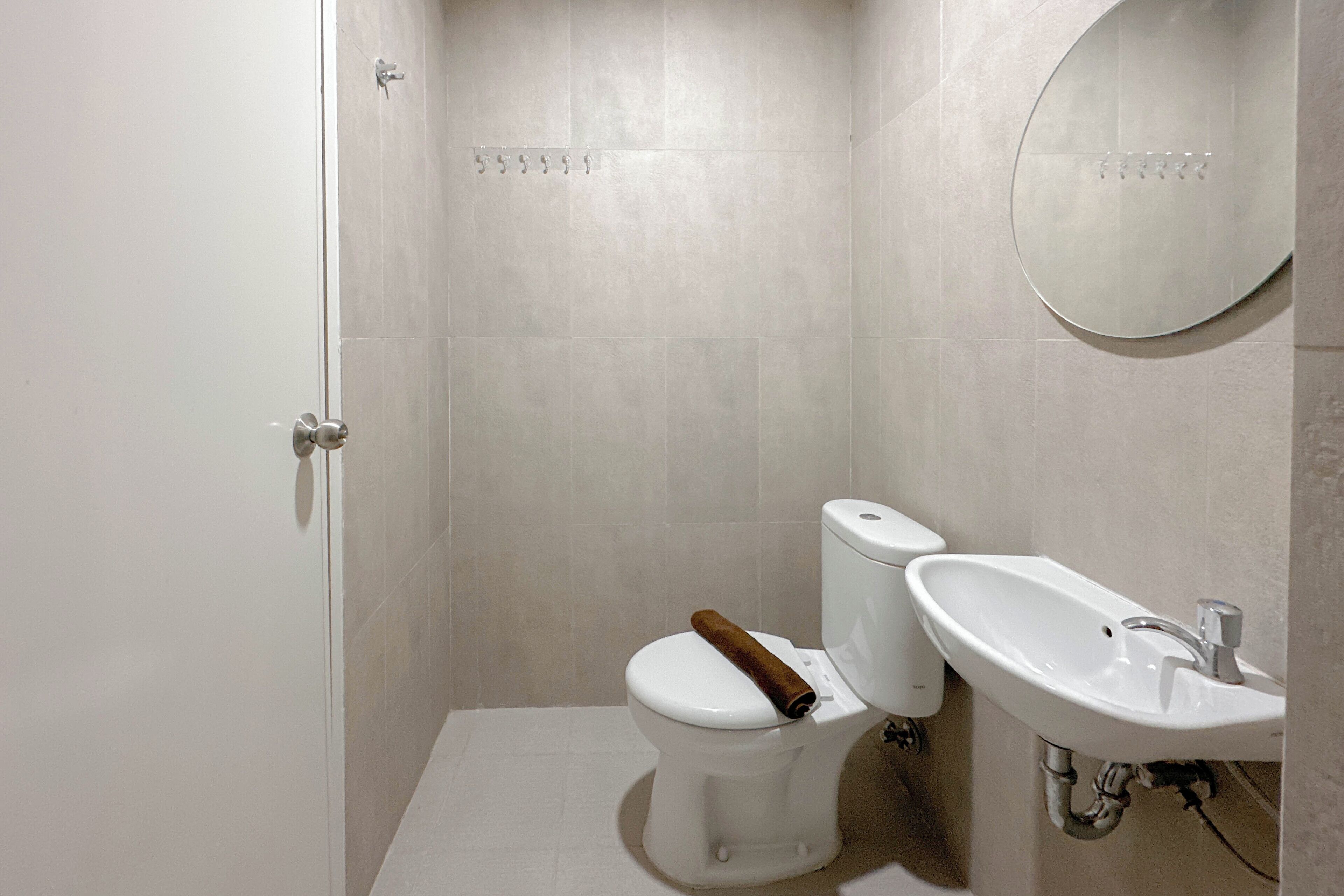 Een badkamer met een toilet, een wastafel en een spiegel.