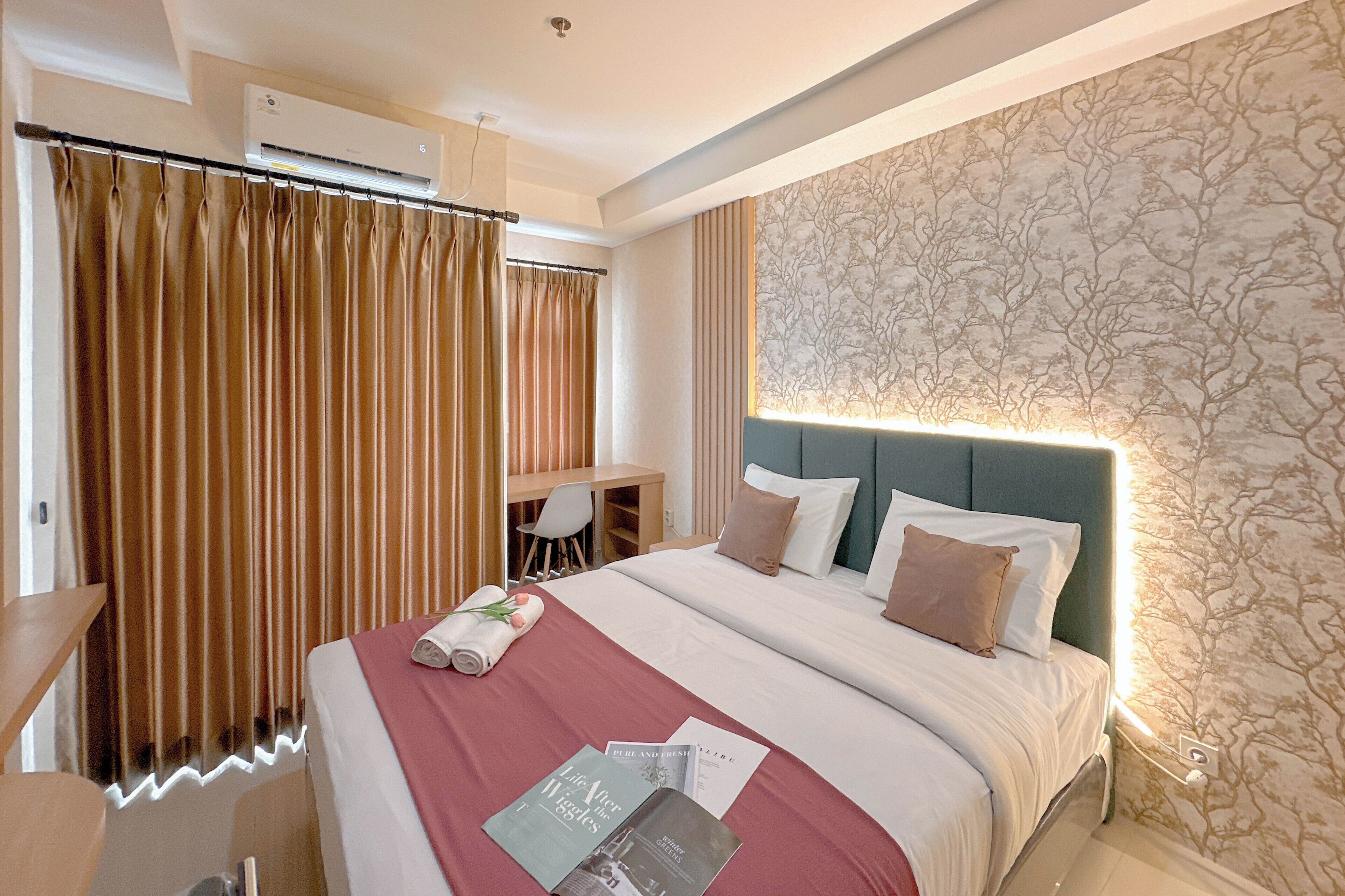 A hotel room with a bed, a desk, and a chair.