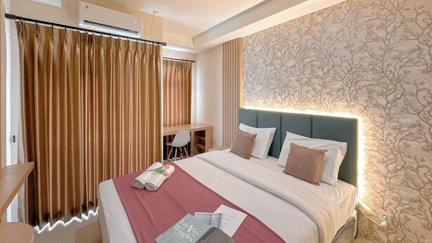 Een hotelkamer met een bed, een bureau en een stoel.
