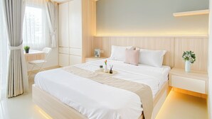 A modern bedroom with a large bed, bedside tables, a desk, and a chair. - Enjoy Living Studio Apartment At Lrt City Jatibening (Bekasi)