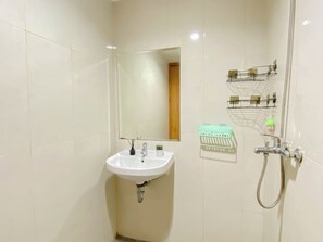 Ein Badezimmer mit Waschbecken, Spiegel und Dusche.