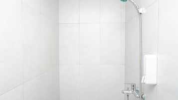 Ducha con cabezal de ducha de mano y panel de control en la pared.