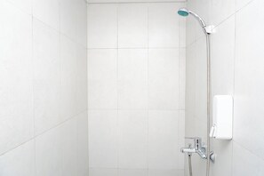 Eine Dusche mit Handbrause und fest installiertem Bedienfeld.