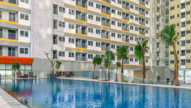 Una piscina con un edificio moderno al fondo.