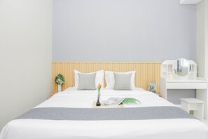 Ein modernes Hotelzimmer mit einem Bett, Nachttisch und Spiegel.