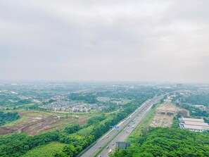 Un'autostrada con diverse corsie, immersa nel verde e fiancheggiata da edifici.