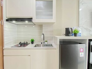 Una cocina moderna con un refrigerador de acero inoxidable, una estufa a gas y un lavamanos.