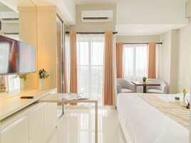 A hotel room with a bed, a TV, a desk, and a chair.
