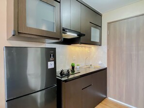 Eine moderne Küche mit einem Edelstahl-Kühlschrank, einem Einbauherd und einem Spülbecken.