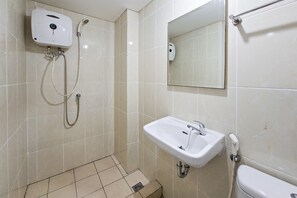 A bathroom with a shower, sink, toilet, and a mirror. - Cozy And Decent Studio Room At Apartment M-Town Residence (Gading Serpong)