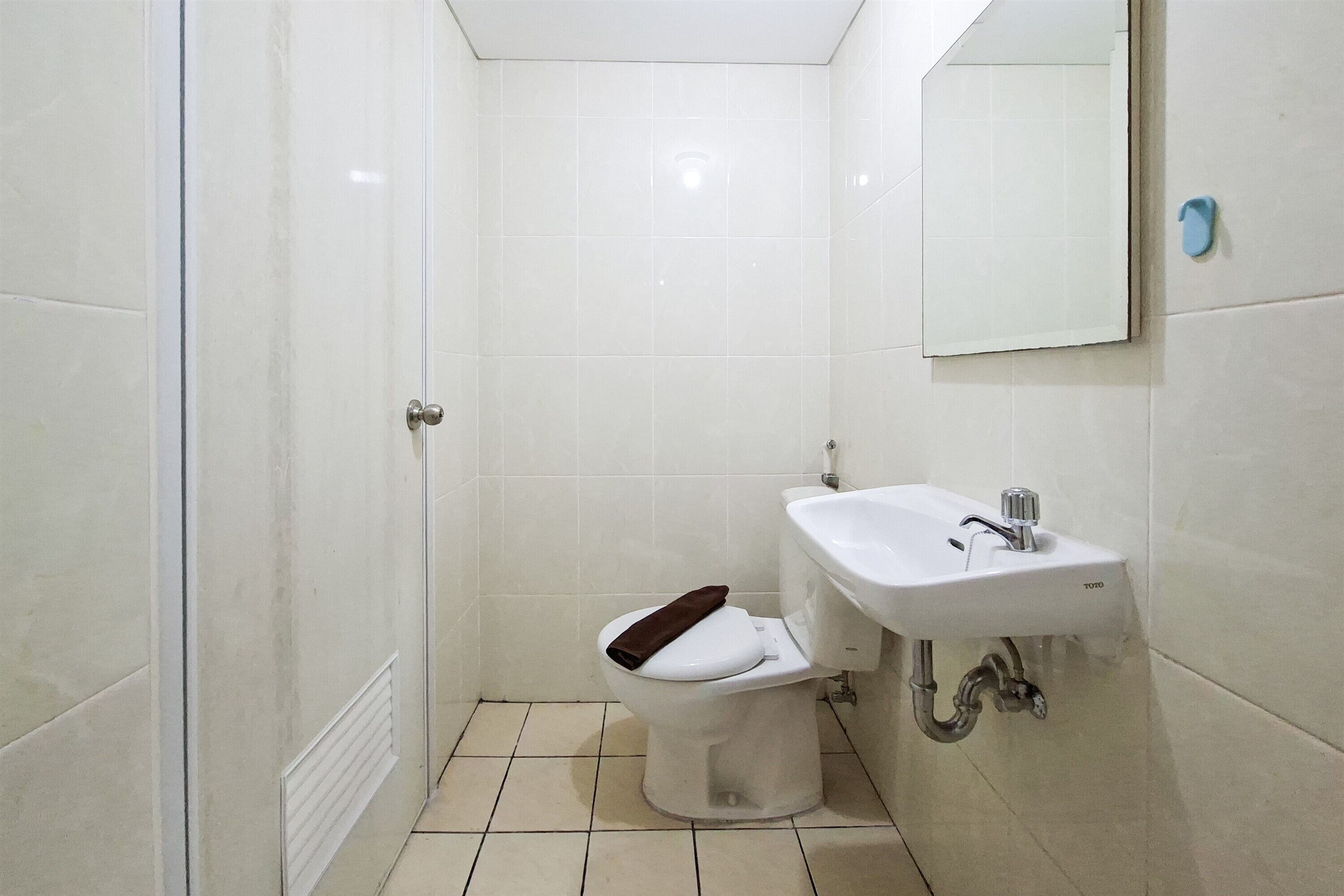 Un bagno con il water, lavandino e specchio.