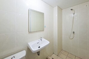 Un baño con lavabo, espejo, inodoro y ducha.