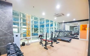 A gym with treadmills, weight machines, and dumbbells. - Best Deal Studio At Mataram City Apartment (Ngaglik)