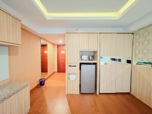 Una cocina compacta con armarios de madera, un refrigerador integrado y una pequeña encimera.