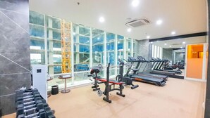 Ett gym med löpband, styrketräningsmaskiner och hantlar.