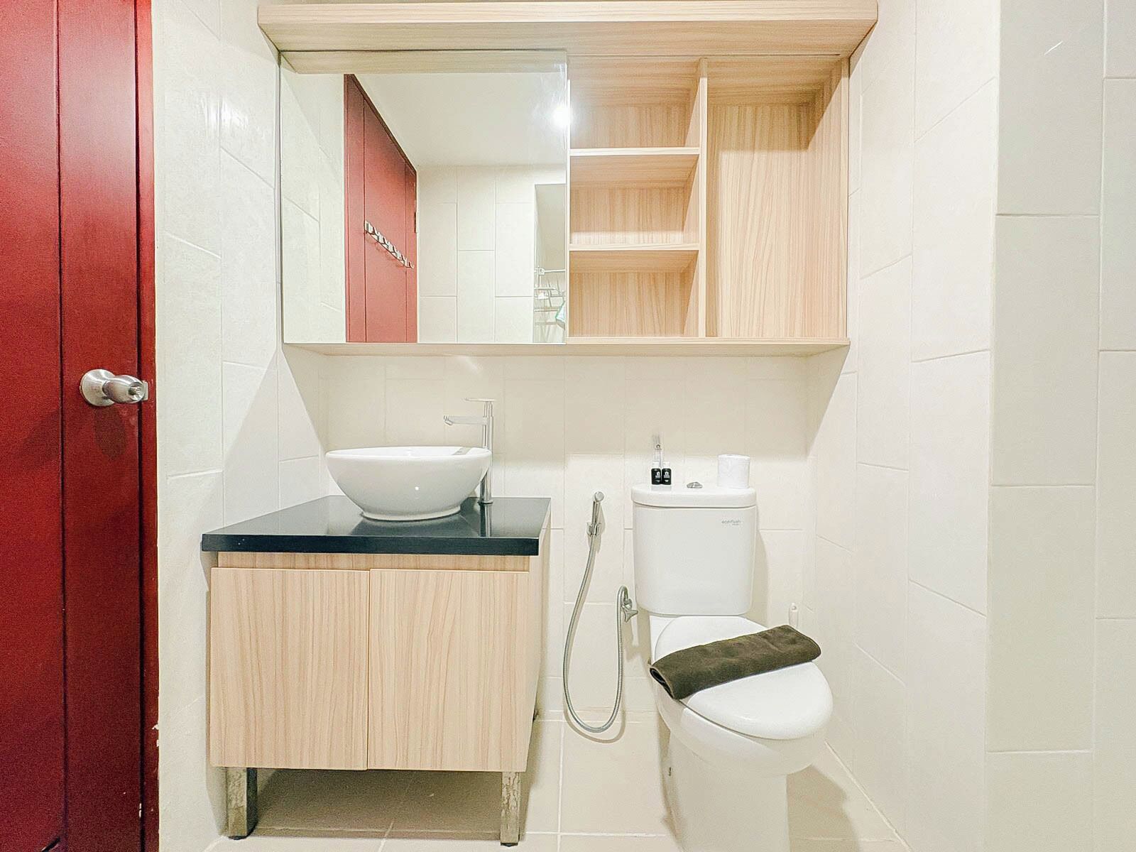 A bathroom with a white sink, a toilet, and a mirror above the sink.