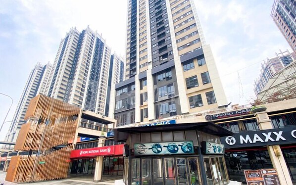 A commercial area with high-rise buildings, a bank, and various shops including a restaurant.