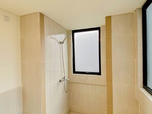 A small, enclosed shower area with a window, tiled walls, and a visible electrical outlet. - 5 Pax Convenient And Homey 3Br At Meikarta Apartment (Cikarang)