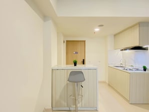 Uma cozinha moderna com uma ilha central, fogão embutido e uma pia.