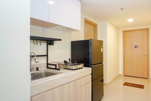 Eine kleine Küche mit Spüle, Herd und Kühlschrank.