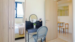 Una camera da letto con un letto, una scrivania con uno specchio, una sedia e un tavolino con sedie.