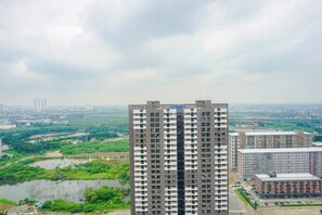 Ein Hochhaus mit mehreren Stockwerken, umgeben von Grünflächen und einem Gewässer.