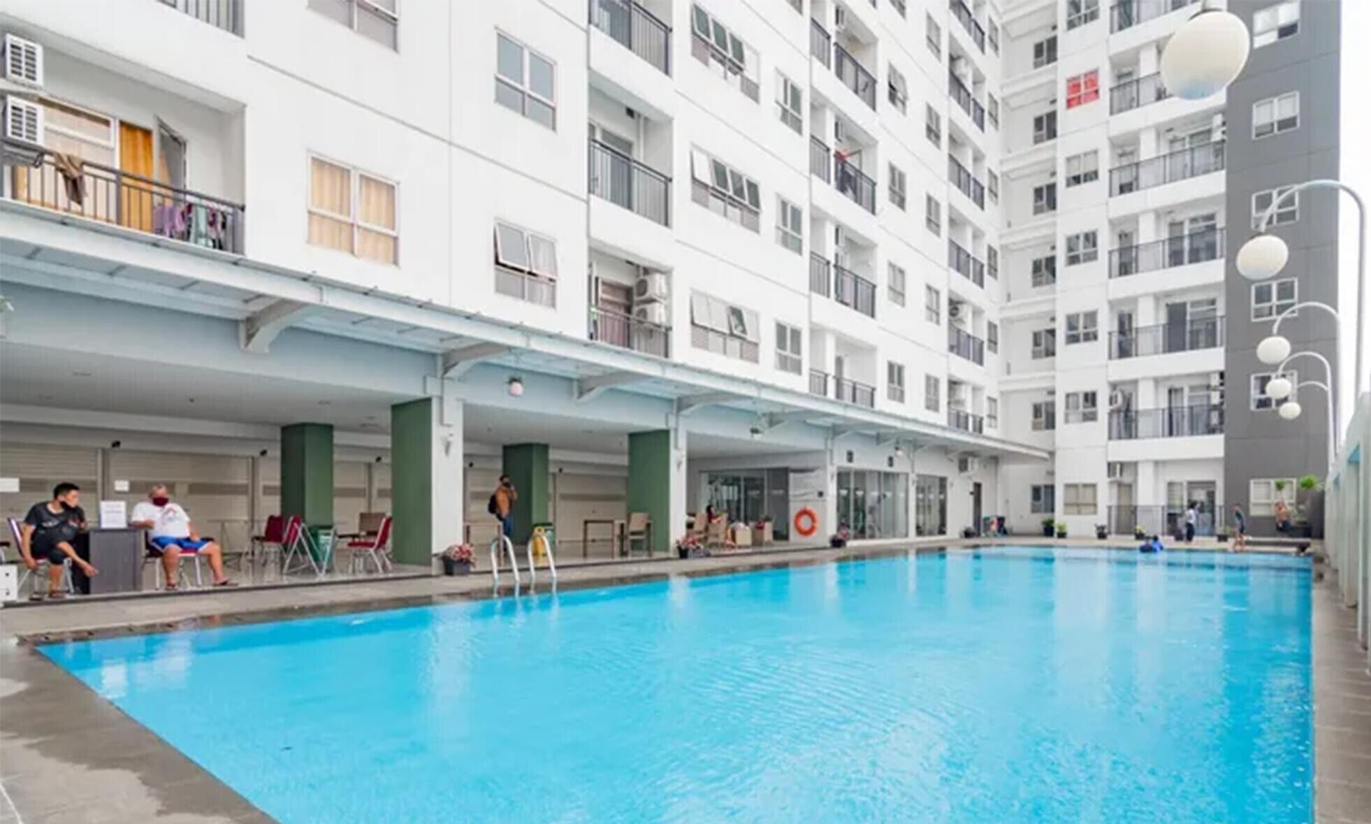 An indoor swimming pool with a covered area, multiple balconies, and a modern building facade.