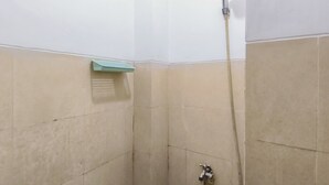A small, tiled shower area with a handheld showerhead and a wall-mounted faucet. - Restful And Warm Studio At Apartment Menara Rungkut (Surabaya)