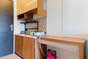 Eine Küche mit Holzausstattung, einer Fliesenküchenwand und einem Gasherd.
