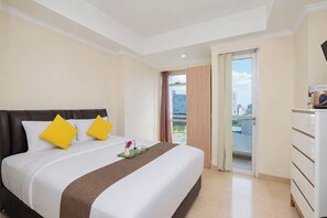 A hotel room with a bed, a small table with a tray, a dresser, and a balcony door. - Strategic Location Studio For 2 Pax At Menteng Park Apartment (Jakarta)