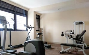 A gym with exercise equipment including treadmills, a stationary bike, and weight machines. - Comfy And Minimalist Studio Apartment Metropark Condominium Jababeka (Cikarang)