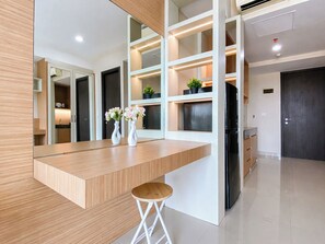 Eine moderne Küche mit einer Holzarbeitsplatte, weißen Schränken und einem schwarzen Kühlschrank.